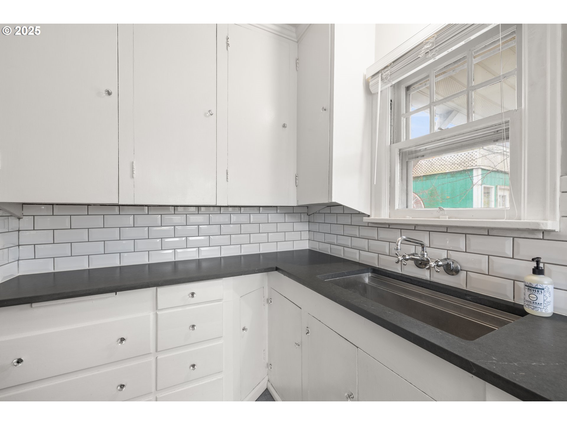 7104 Southeast Tolman Street Portland, OR 97206 - Photo 13 of 34 a kitchen with granite countertop white cabinets and sink