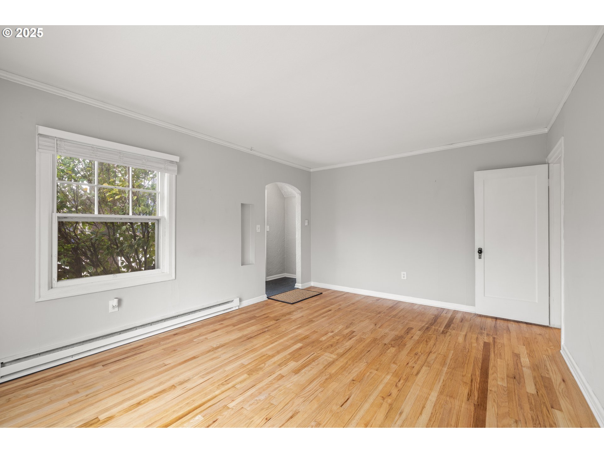 7104 Southeast Tolman Street Portland, OR 97206 - Photo 8 of 34 a view of an empty room with wooden floor and a window