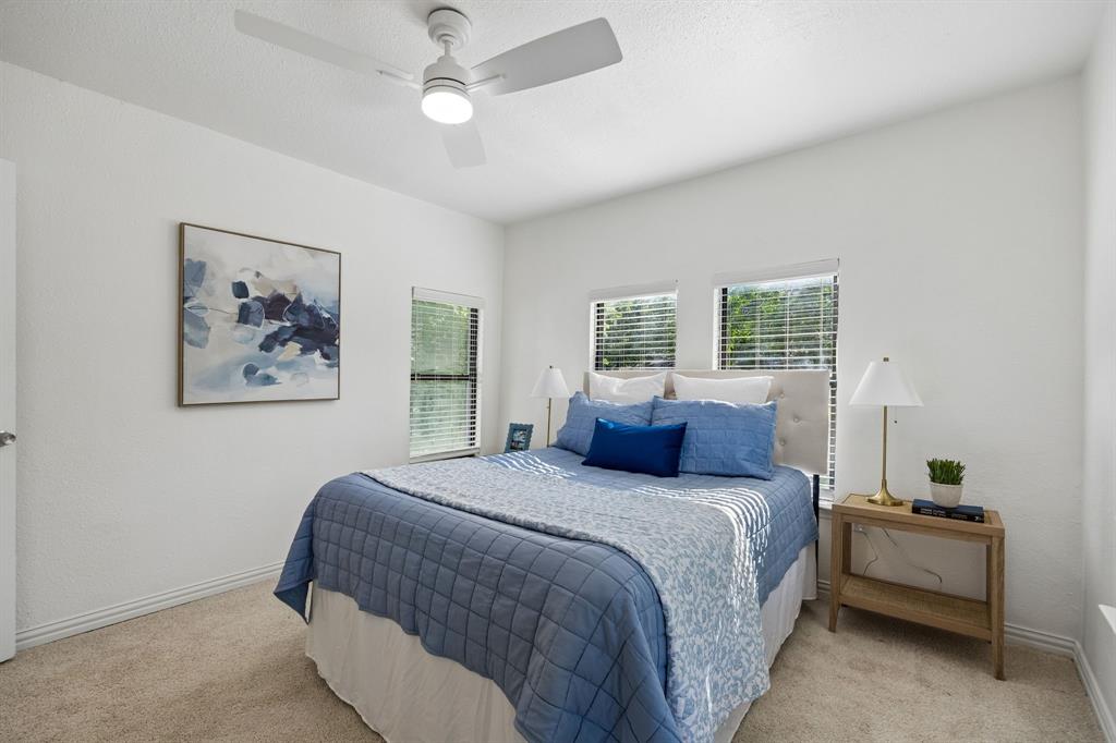 806 North Ruddell Street Denton, TX 76209 - Photo 23 of 26 a bedroom with a large bed and a chandelier
