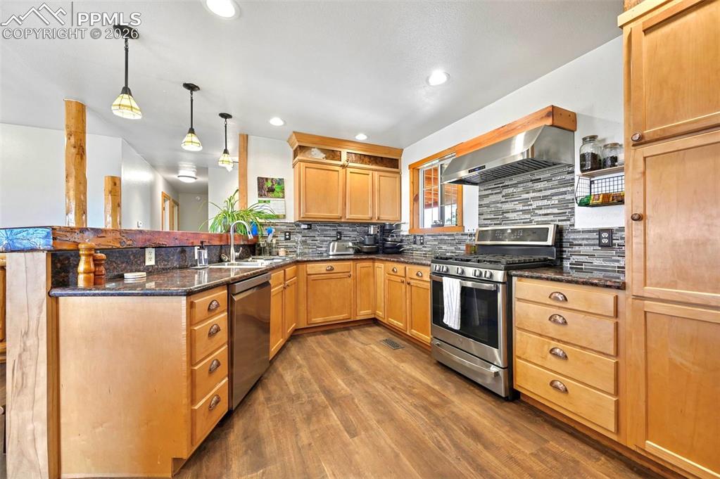 18560 Chelton Road Ramah, CO 80832 - Photo 5 of 34 a kitchen with stainless steel appliances kitchen island granite countertop a stove a sink and white cabinets
