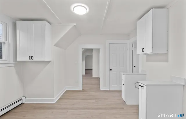 a view of a kitchen with wooden floor and electronic appliances