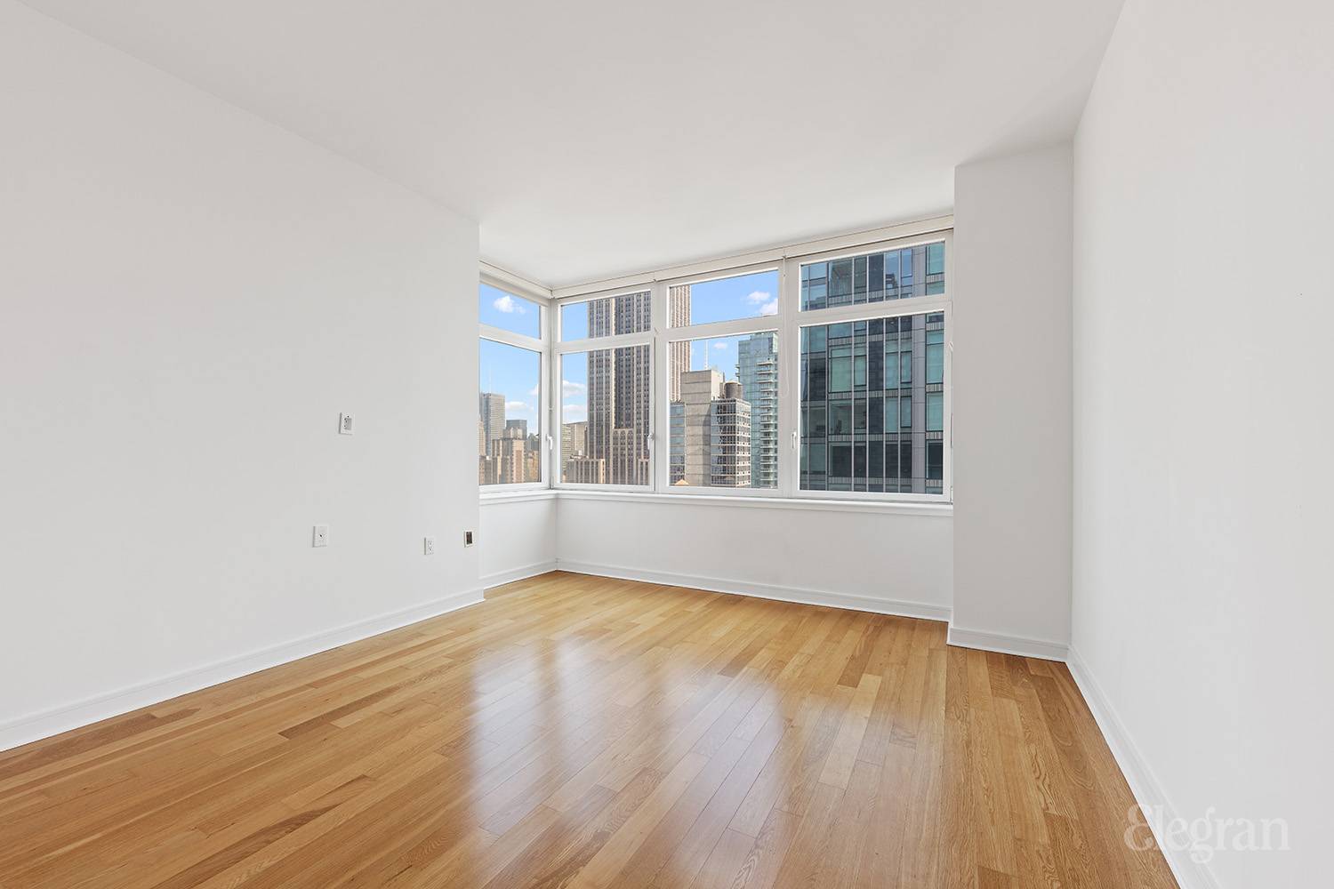 11 East 29th Street, Unit 32C Manhattan, NY 10016 - Photo 5 of 8 a view of an empty room with wooden floor and a window