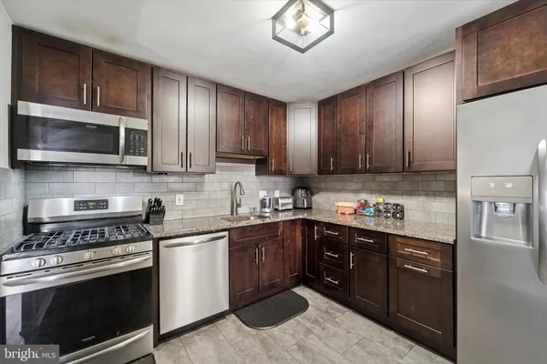 a kitchen with cabinets wooden floor and stainless steel appliances