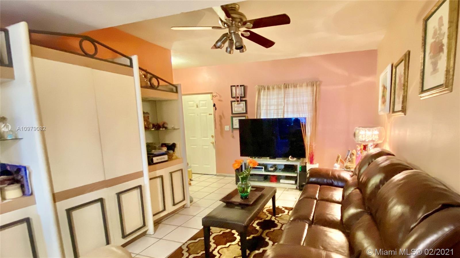 8340 Northwest 103rd Street, Unit 205D Hialeah Gardens, FL 33016 - Photo 4 of 10 a view of a livingroom with furniture and a flat screen tv