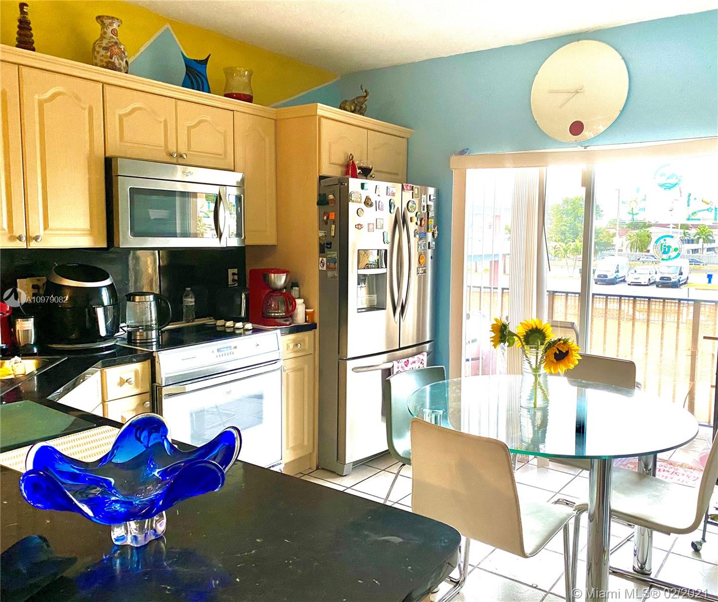 8340 Northwest 103rd Street, Unit 205D Hialeah Gardens, FL 33016 - Photo 5 of 10 a kitchen with stainless steel appliances kitchen island granite countertop a refrigerator dining table and chairs