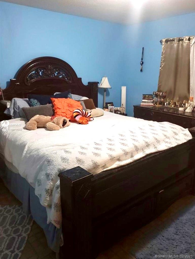 8340 Northwest 103rd Street, Unit 205D Hialeah Gardens, FL 33016 - Photo 10 of 10 a bedroom with a bed and a lamp