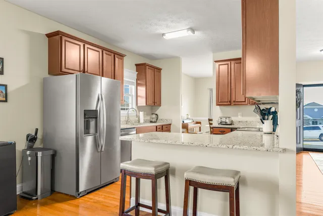 a kitchen with granite countertop a refrigerator and a sink
