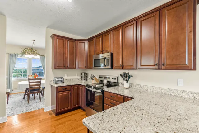 a kitchen with stainless steel appliances granite countertop sink stove and cabinets