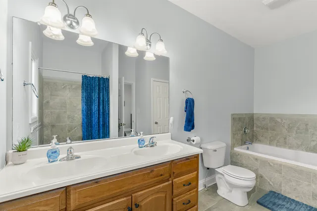 a bathroom with a granite countertop sink a toilet and a mirror