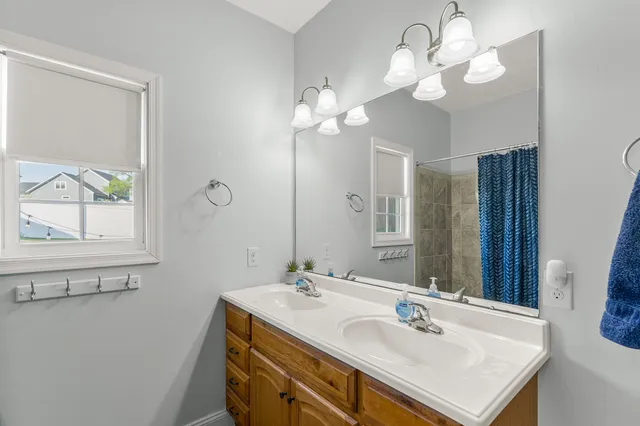 a bathroom with a sink a large mirror and a light fixture