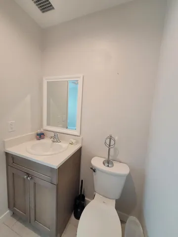 a bathroom with a toilet a sink and mirror