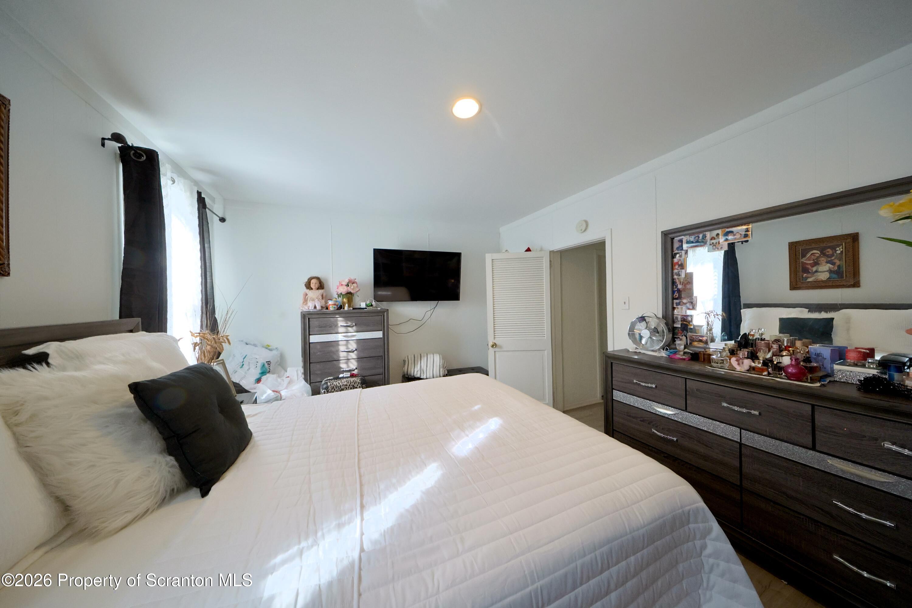1016-1018 Diamond Avenue Scranton, PA 18508 - Photo 10 of 15 a bedroom with a bed a flat screen tv and a dresser