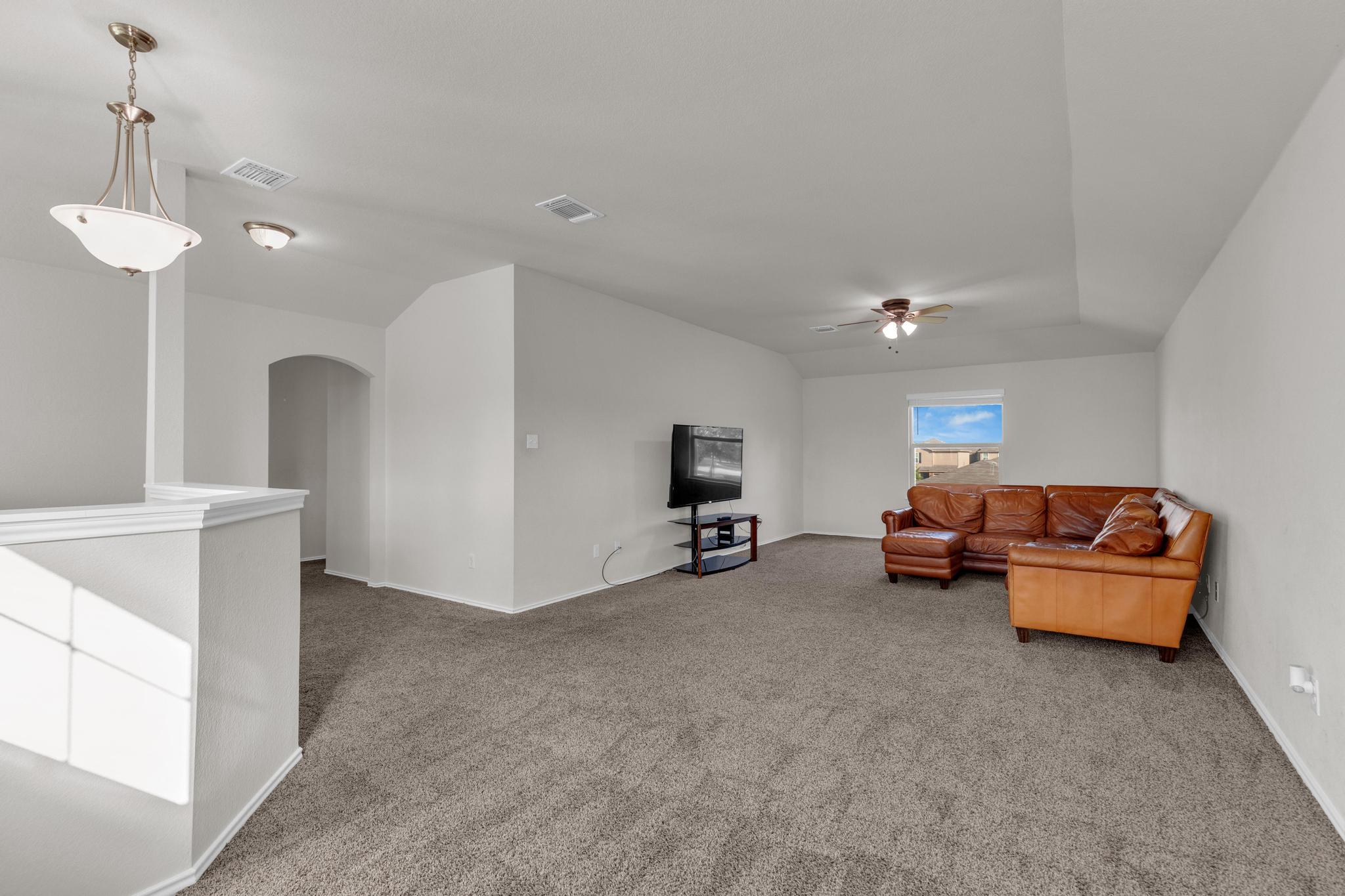 104 Uncle Billy Way Jarrell, TX 76537 - Photo 25 of 38 A spacious upper-level living area offers comfortable carpeting and a bright window view.