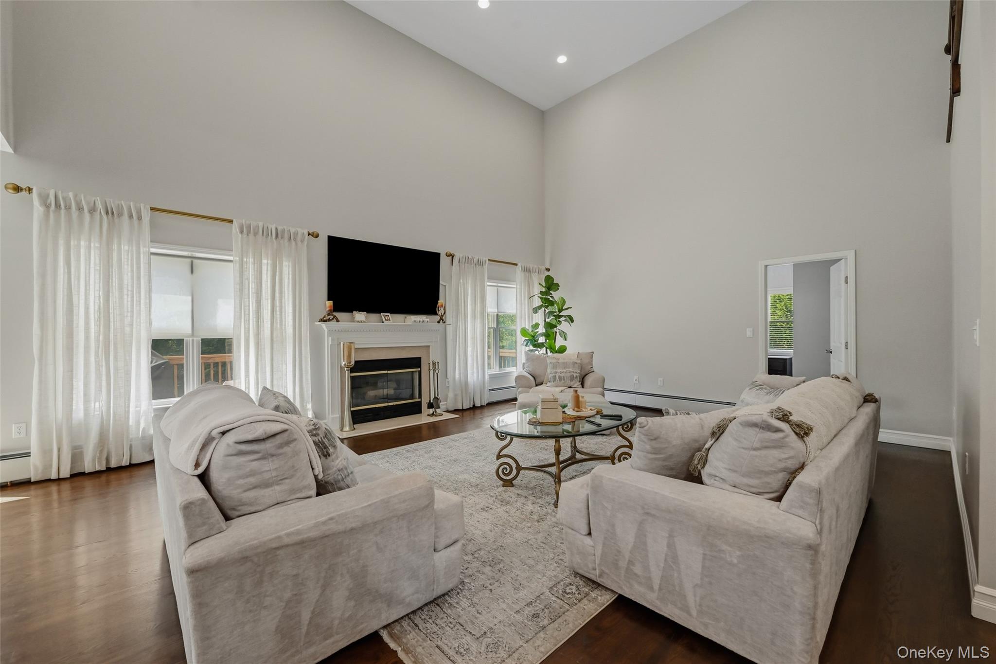 51 Meriwether Trail Congers, NY 10920 - Photo 16 of 50 Spacious living area featuring high vaulted ceilings, rich wood-finish flooring, and a built-in fireplace with a white mantel