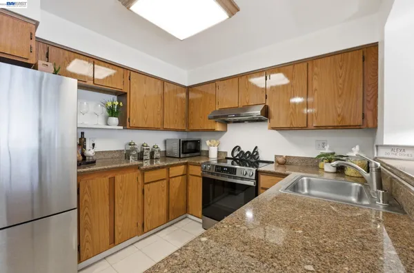 a kitchen with a sink stove top oven and refrigerator