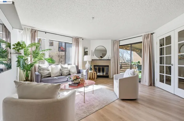 a living room with furniture large window and wooden floor