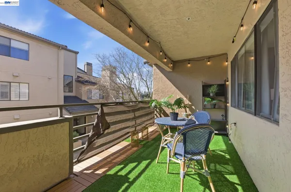 a balcony with chairs and a wooden floor