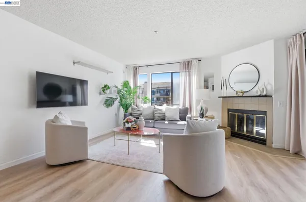 a living room with furniture a flat screen tv and a fireplace