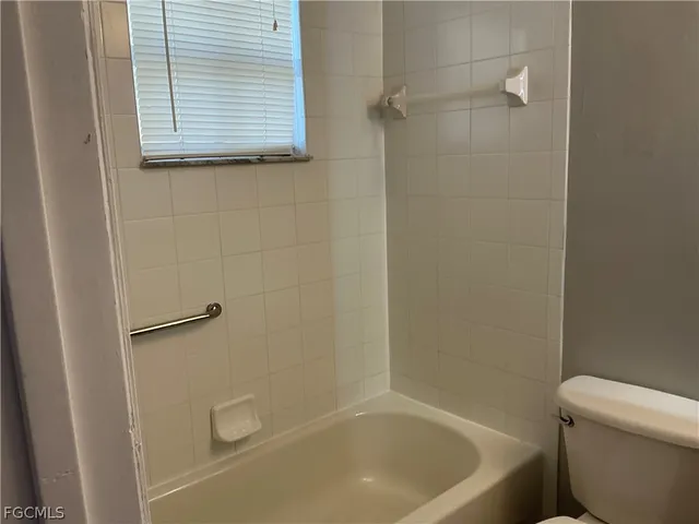 a bath tub sitting next to a white toilet and a sink
