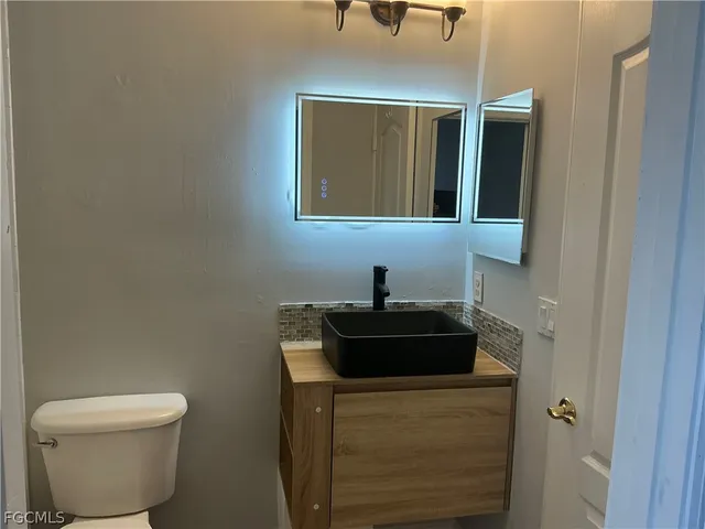 a bathroom with a toilet sink and mirror