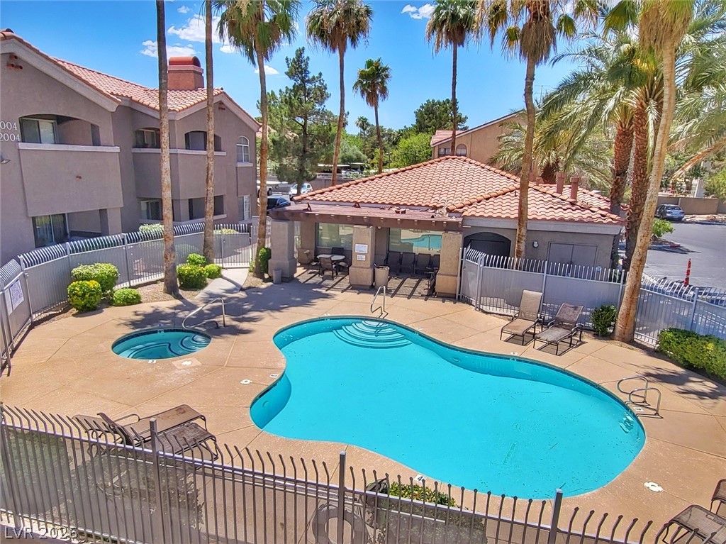 5525 West Flamingo Road, Unit 2040 Las Vegas, NV 89103 - Photo 14 of 15 Lush landscaping surrounds a community pool and spa, providing a serene outdoor retreat.