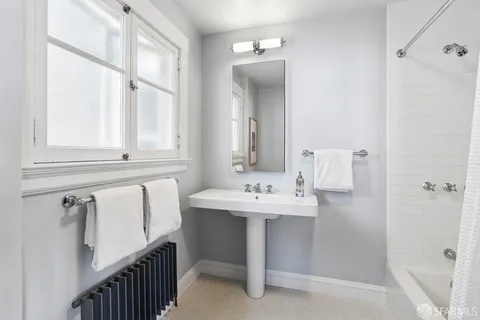 a bathroom with a double vanity sink a mirror and a bathtub