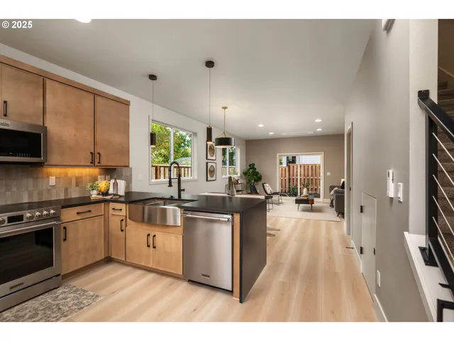 a kitchen with stainless steel appliances granite countertop a stove sink and cabinets