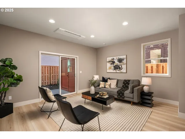 a living room with furniture two window and a potted plant