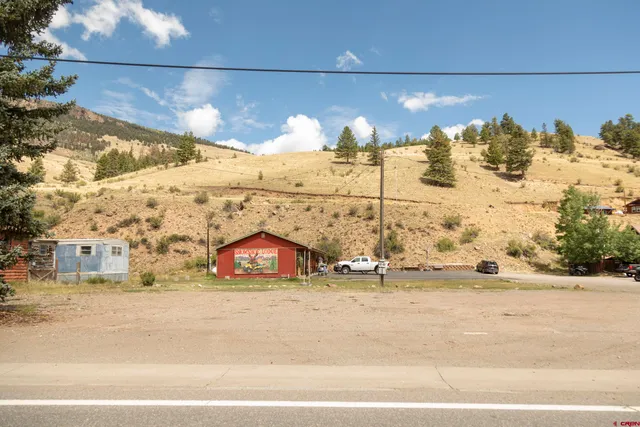 a view of an ocean with a floor to ceiling window next to a yard