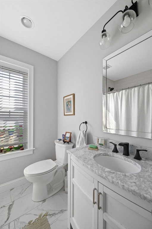 13 Spring Street, Unit 3 Salem, MA 01970 - Photo 18 of 37 a bathroom with a granite countertop sink mirror vanity and toilet
