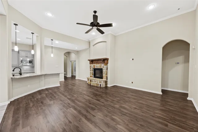a view of empty room with wooden floor and ceiling fan