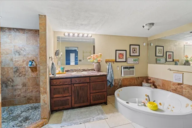 a bathroom with a tub a sink and mirror