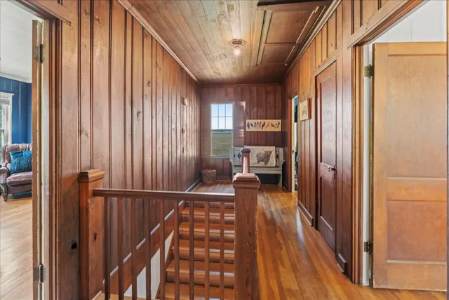 a view of a hallway with wooden floor and staircase