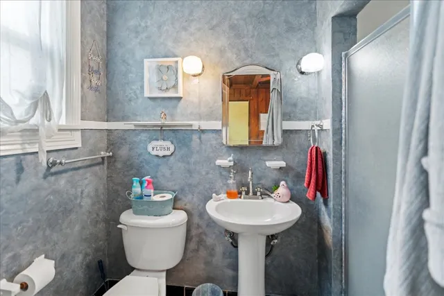 a bathroom with a sink toilet and mirror