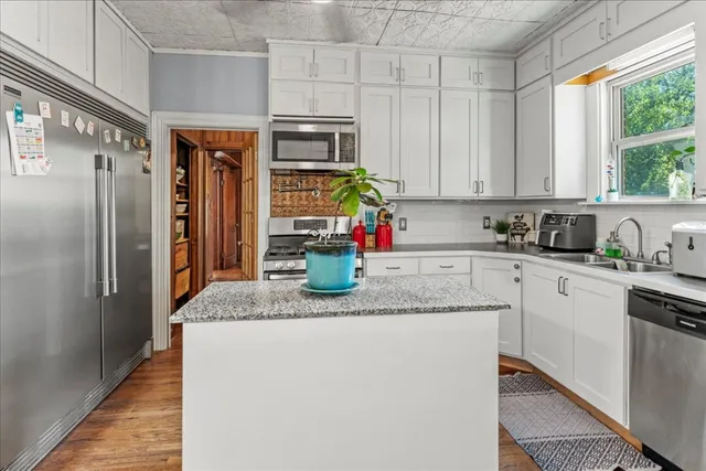 a kitchen with stainless steel appliances granite countertop a refrigerator sink and stove