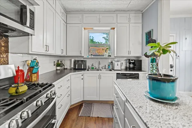 a kitchen with stainless steel appliances granite countertop a stove a sink and a granite counter tops