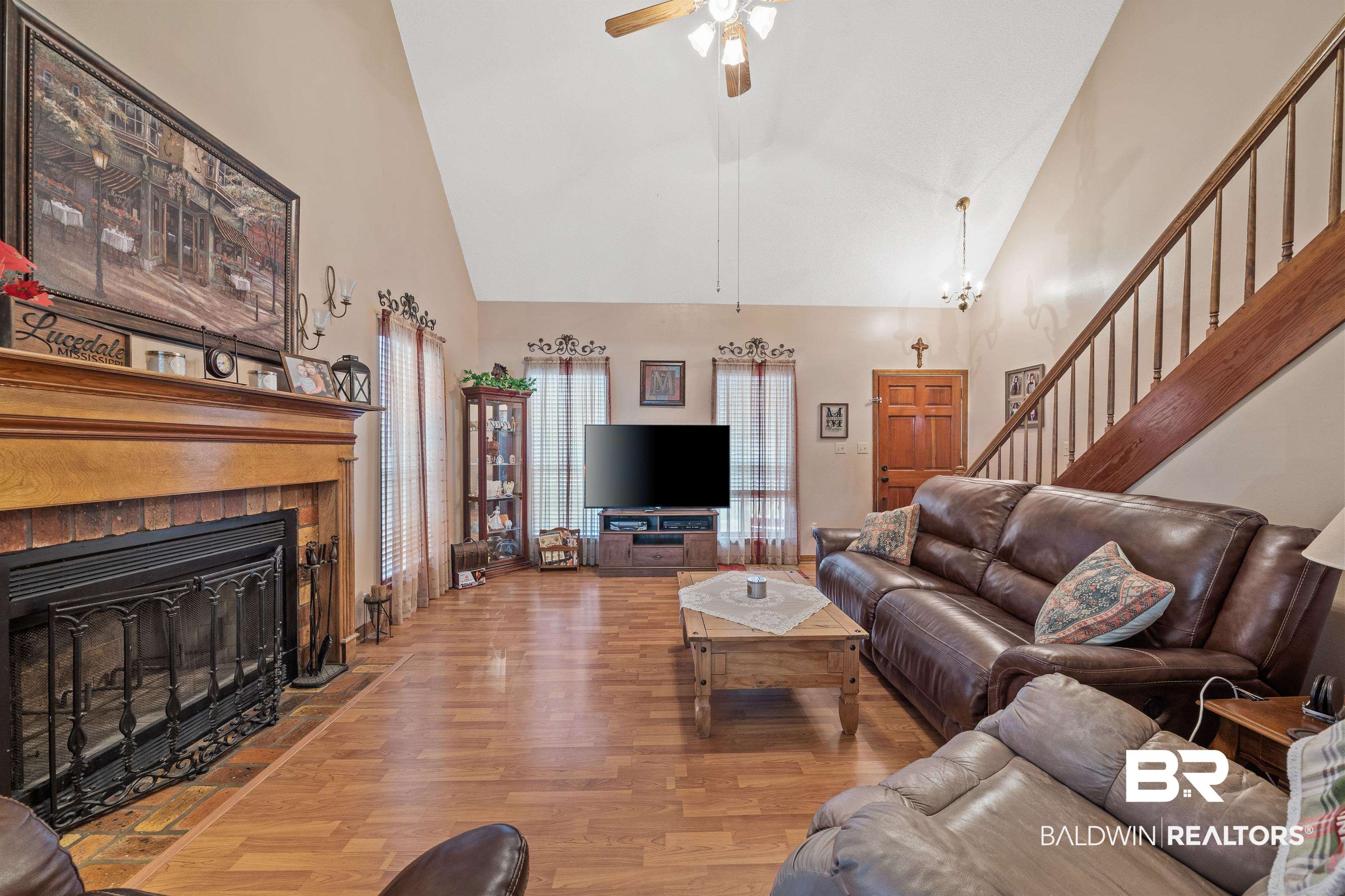 460 Ridgewood Drive Daphne, AL 36526 - Photo 4 of 31 Living room featuring light hardwood / wood-style floors, ceiling fan with notable chandelier, high vaulted ceiling, and a fireplace