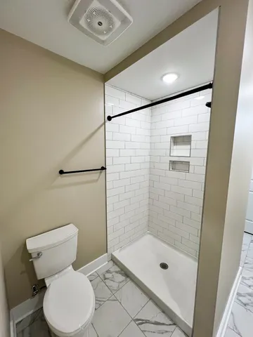 a bathroom with a toilet and a shower