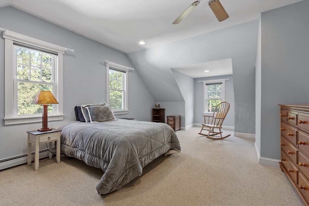 21 High Street Ayer, MA 01432 - Photo 16 of 40 a spacious bedroom with a bed a chandelier and windows