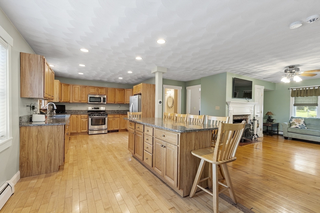 21 High Street Ayer, MA 01432 - Photo 5 of 41 a large kitchen with kitchen island a large counter top space a sink stainless steel appliances and cabinets