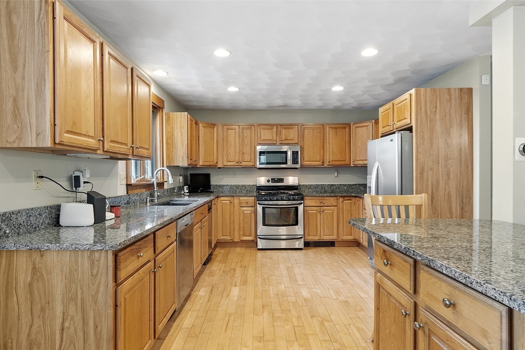 21 High Street Ayer, MA 01432 - Photo 5 of 40 a kitchen with stainless steel appliances granite countertop a stove a sink dishwasher a refrigerator and cabinets with wooden floor