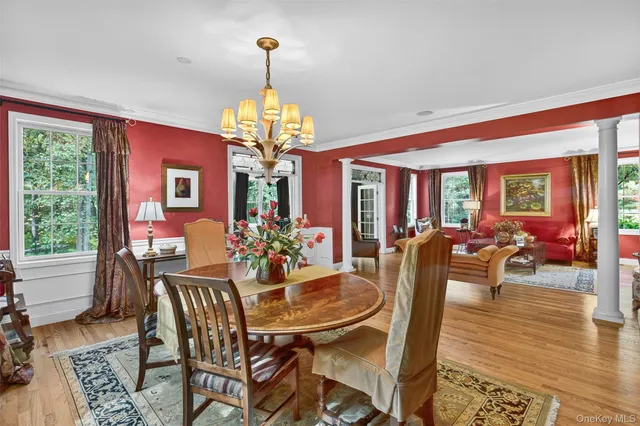 a view of a dining room with furniture a chandelier and wooden floor