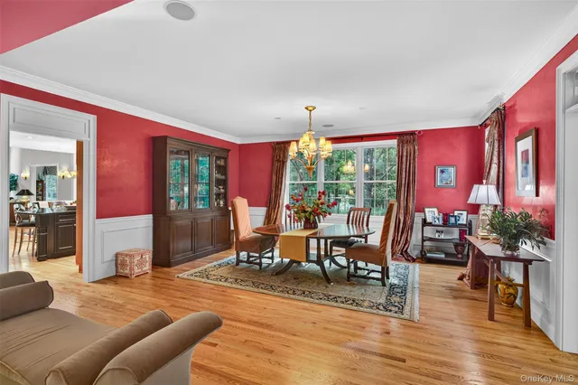 a living room with furniture large window and wooden floor
