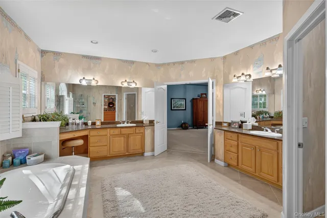 a spacious bathroom with a granite countertop tub sink and mirror