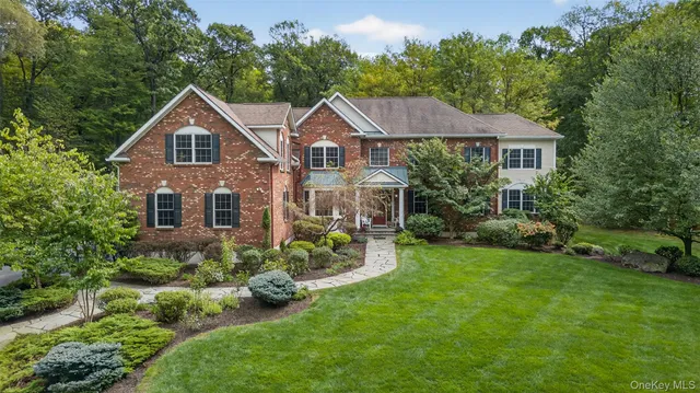 a front view of a house with yard and green space