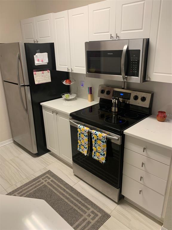 5140 Northridge Road, Unit 204 Sarasota, FL 34238 - Photo 3 of 12 a kitchen with stainless steel appliances a stove a microwave a refrigerator and cabinets
