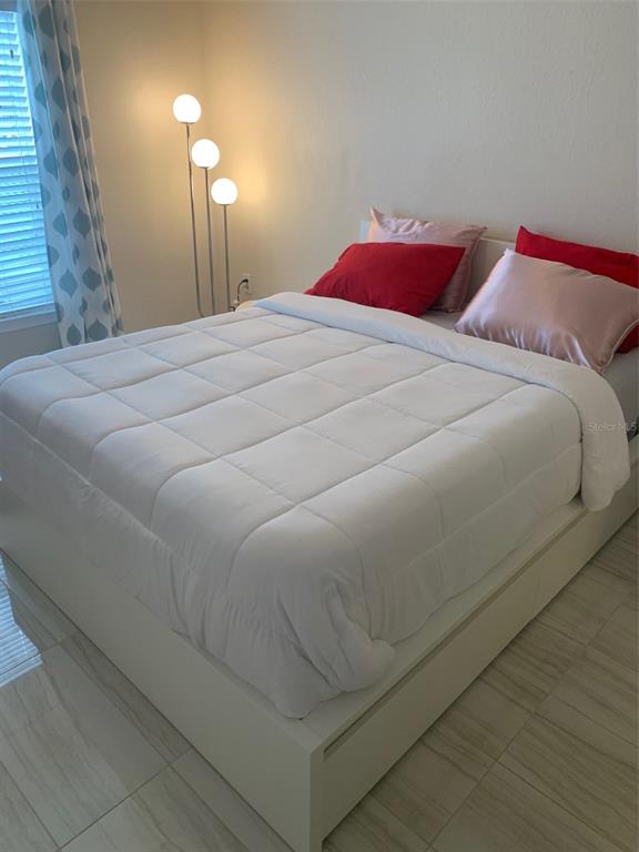 5140 Northridge Road, Unit 204 Sarasota, FL 34238 - Photo 4 of 12 a bed sitting in a bedroom next to a lamp