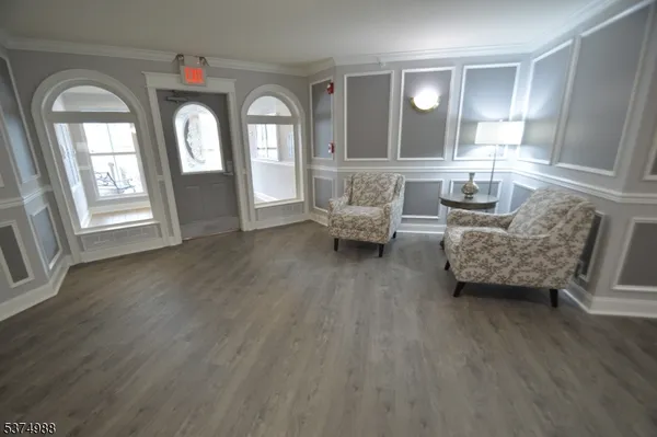 a living room with furniture and a large mirror next to a window