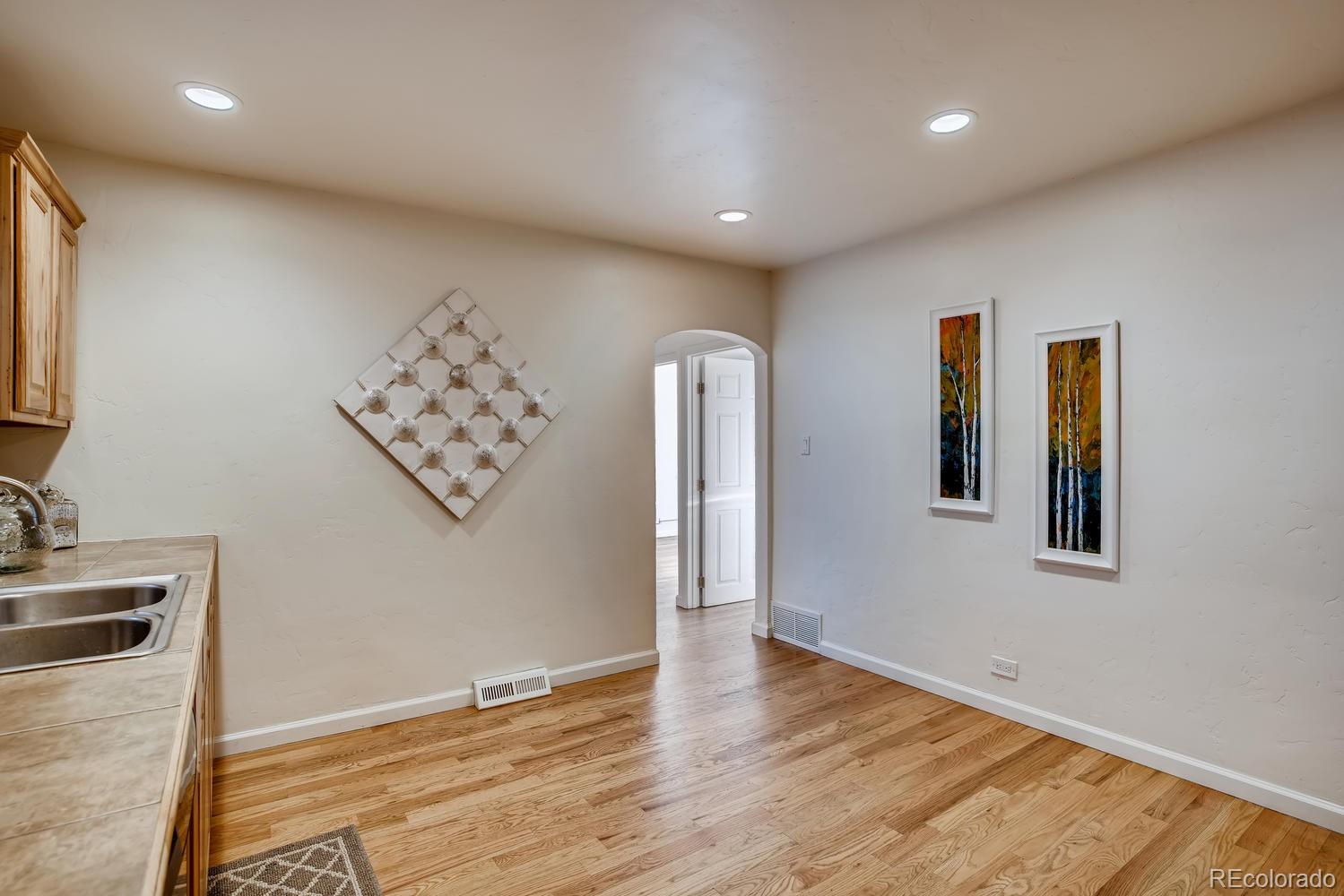 1718 South Decatur Street Denver, CO 80219 - Photo 8 of 28 an empty room with wooden floor and cabinet