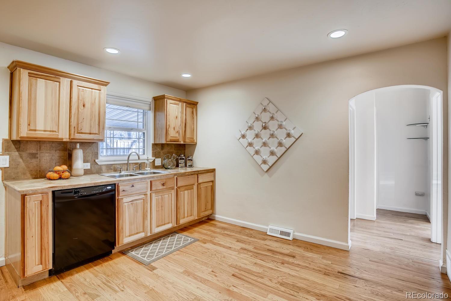 1718 South Decatur Street Denver, CO 80219 - Photo 9 of 28 a kitchen with stainless steel appliances granite countertop a stove a sink and a refrigerator